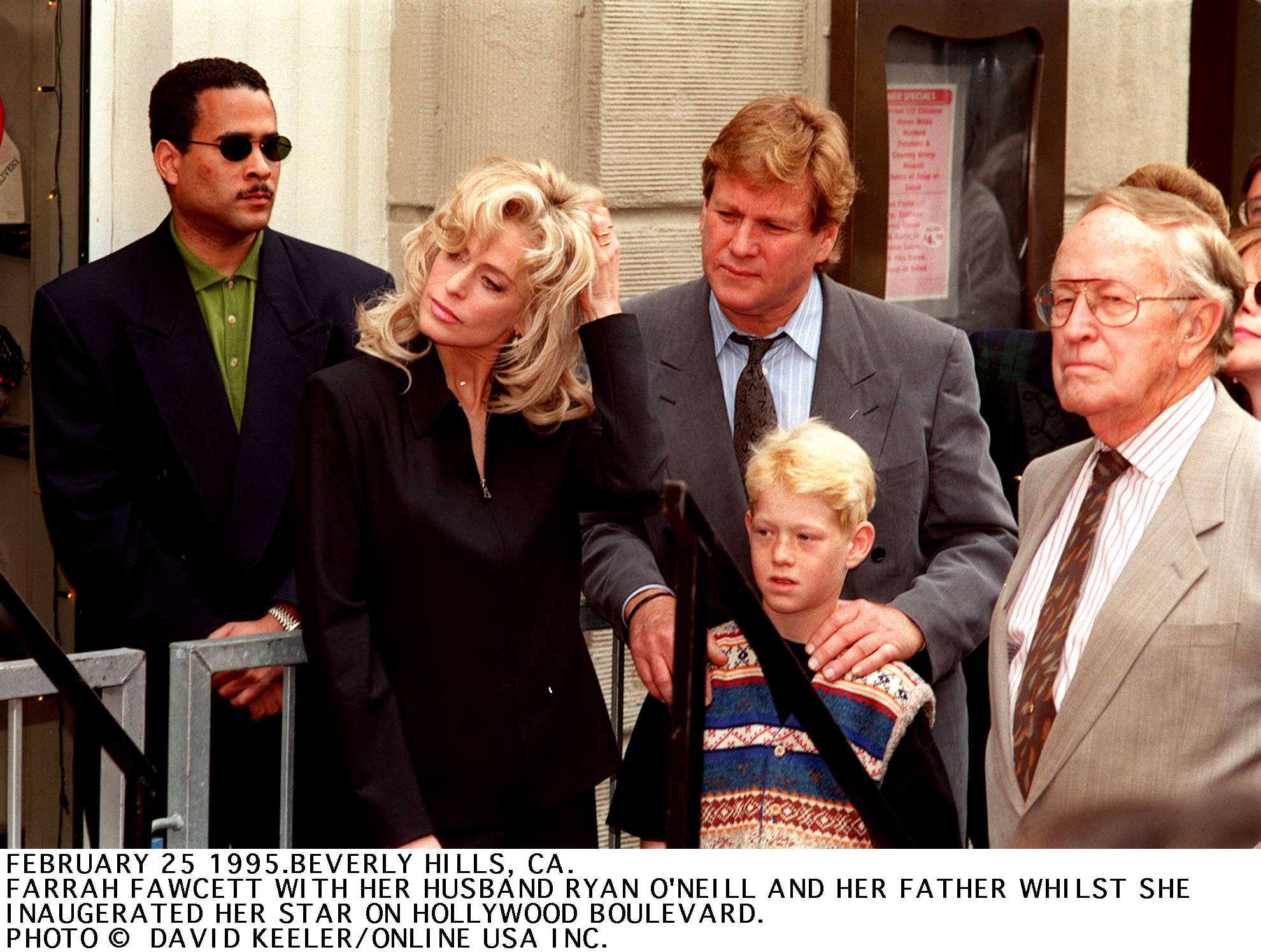 Farrah Fawcett with Ryan O'Neal and their son, Redmond O'Neal, on Hollywood Boulevard, where Fawcett received her star on February 25, 1998, in Los Angeles | Source: Getty Images