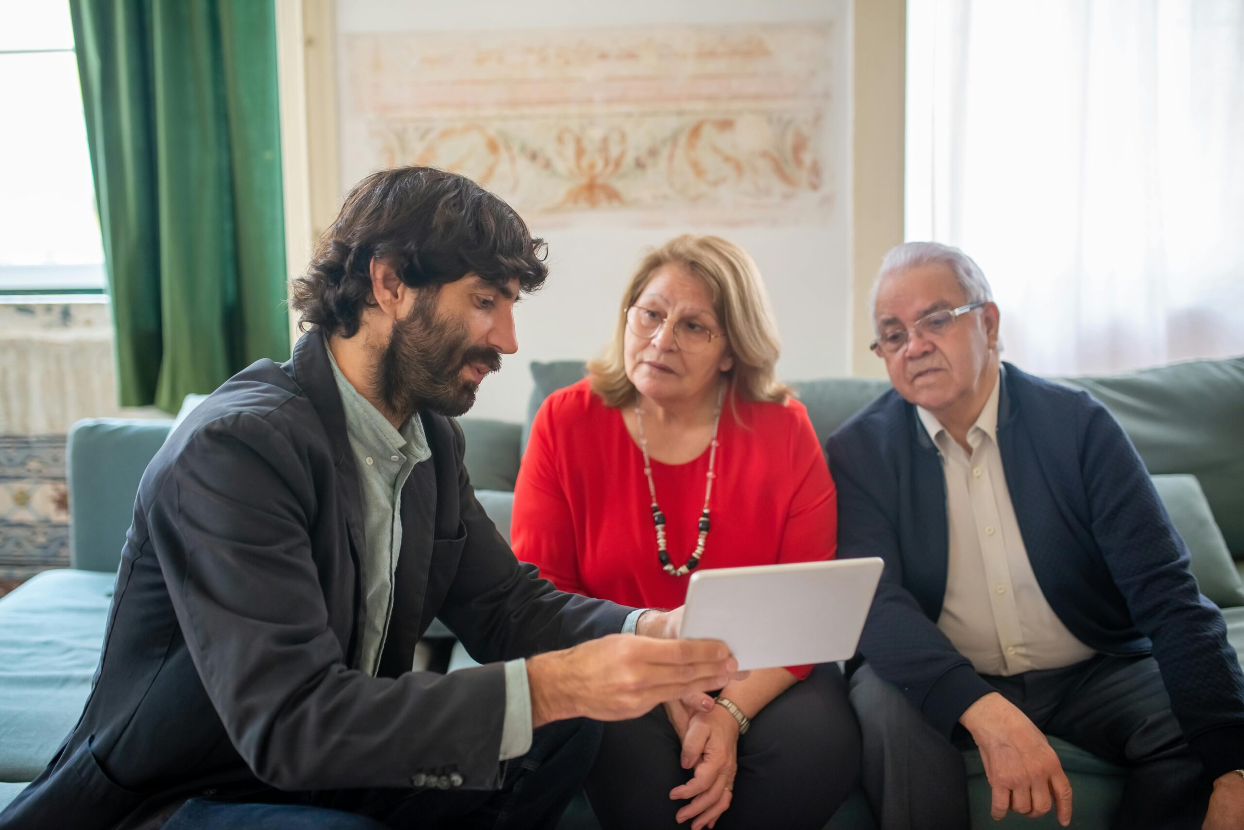 A man sitting and discussing paper work with his parents | Source: Pexels