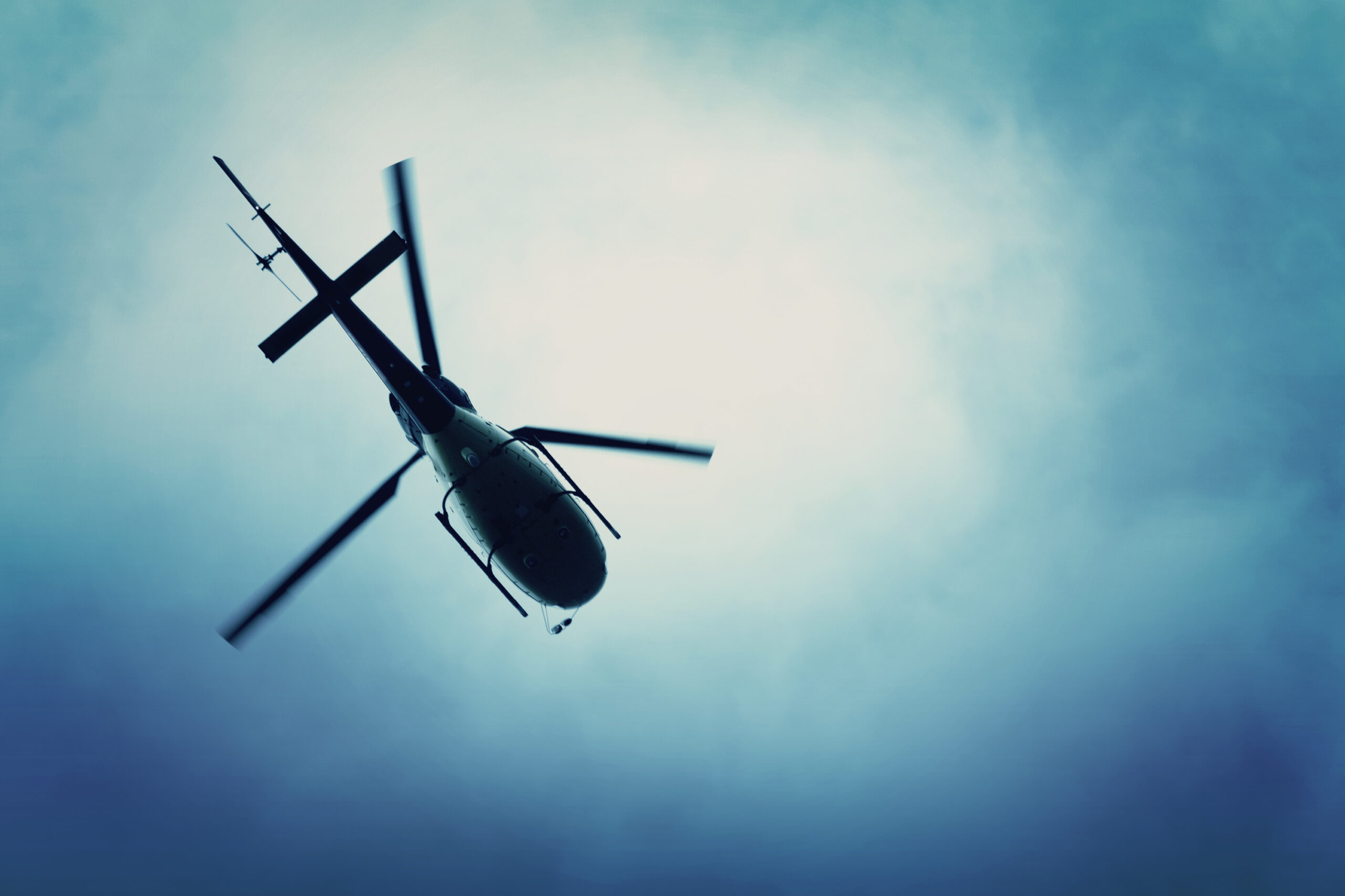 Helicopter flying in the blue sky. | Source: Shutterstock